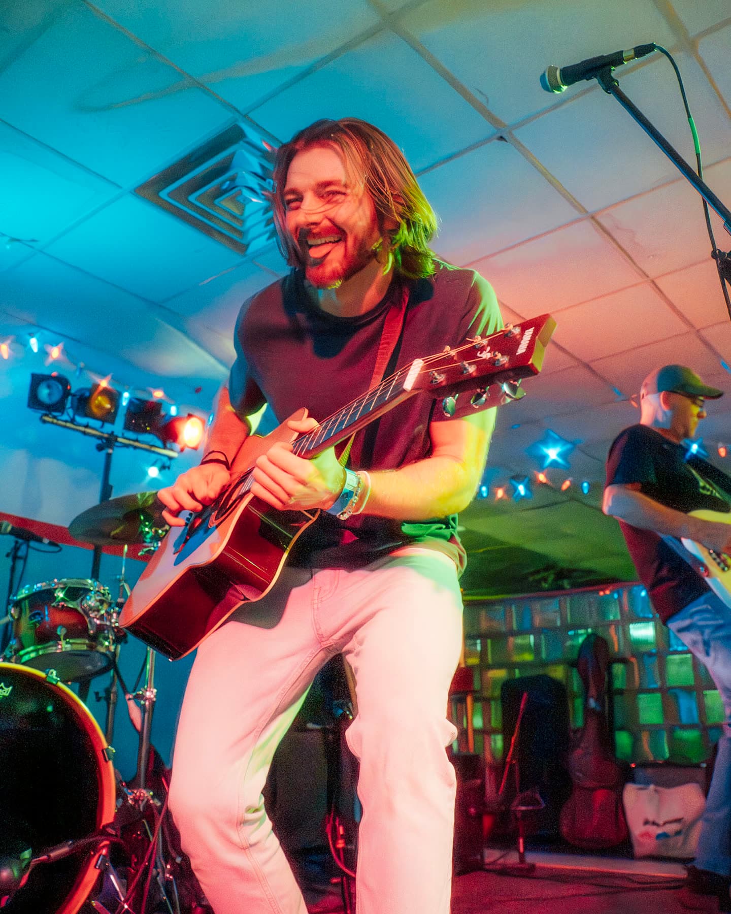 Lee mid-song on acoustic under the stage lights